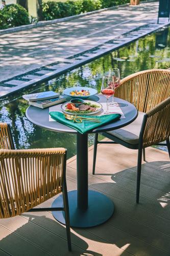 a table with food and wine glasses next to a pool at iTree Guanhu Academy Huizhou West Lake in Huizhou