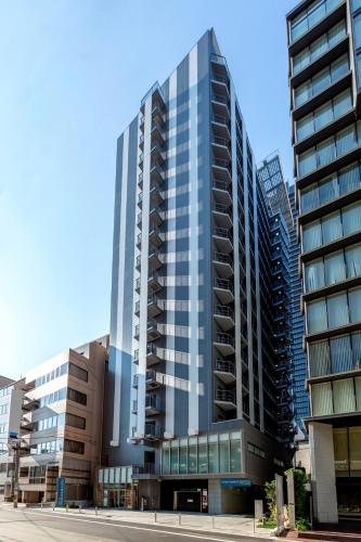 a tall building with glass windows in a city at Four Points Flex by Sheraton Osaka Kitahama in Osaka