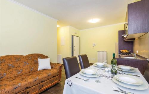 a dining room with a table and a couch at Nice Apartment In Calvle With Wifi in Podrvanj