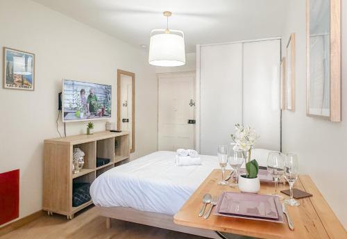 - une chambre avec un lit et une table avec des verres à vin dans l'établissement Canopee rue Carnot Annecy, à Annecy