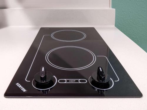 a stove top with two knobs on top of it at ECHO Suites Extended Stay by Wyndham Indianapolis AmeriPlex in Indianapolis