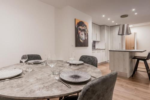 une salle à manger avec une table et des chaises et une cuisine dans l'établissement Le 002 - Proche Telecabine - Terrasse, à Saint-Gervais-les-Bains