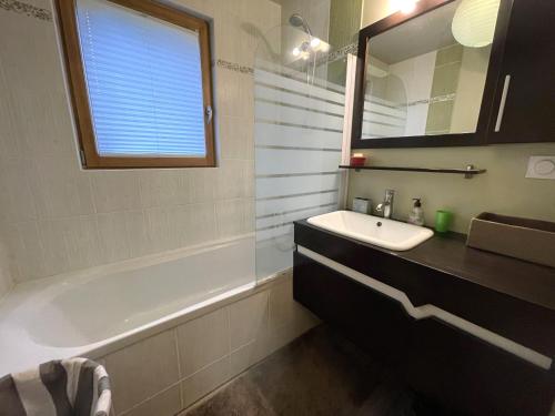 une salle de bain avec un lavabo, une baignoire et un miroir dans l'établissement Villa avec WIFI, jardin, sur l'étang de Ploumanac'h à PERROS-GUIREC - Réf 406, à Perros-Guirec