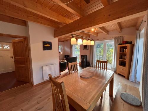 a kitchen and dining room with a wooden table and chairs at Haus Anemone in Wieck