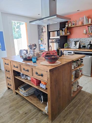 - une cuisine avec un îlot en bois et un comptoir dans l'établissement Bel appartement avec jardin, à Montpellier