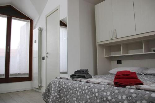 Un dormitorio con una cama con una toalla roja encima. en La Mansarda, en Melzo