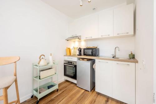 une cuisine avec des armoires blanches et un évier dans l'établissement N2 Les Arcades de Montaudry - Terrasse - Parking, à Albi