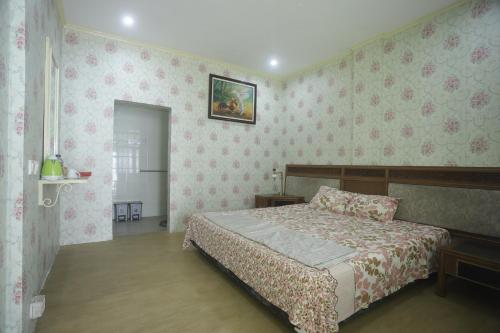 a bedroom with a bed and pink wallpaper at De Karanganjar Inn in Berni