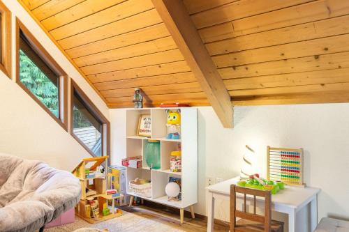 a living room with a wooden ceiling and a table at Uplake Forest Retreat in Kenmore