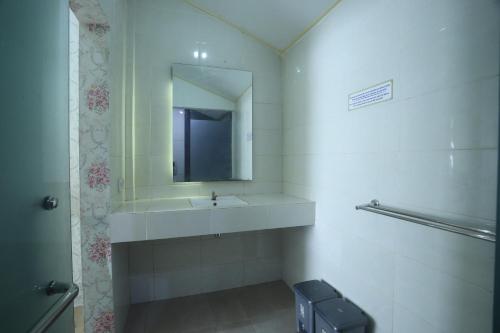 a bathroom with a sink and a mirror at De Karanganjar Inn in Berni