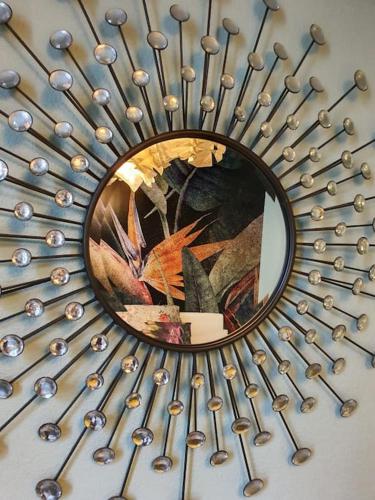 un miroir sur un mur avec un bouquet d'objets en argent dans l'établissement L'Orée du Parc, Lyon 6 - Parc Tête d'Or, à Lyon