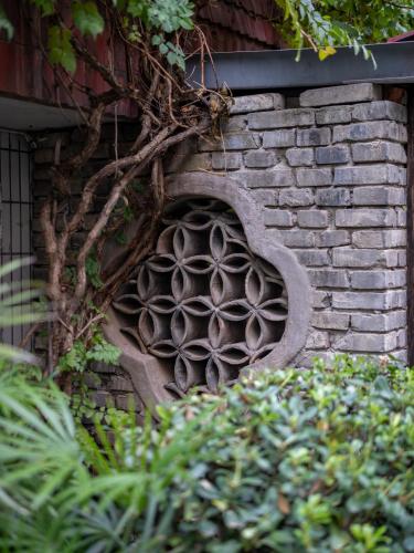 a brick wall with a design on it at PuYuan Laoyangfang Huayuan GuestHouse in Xi'an