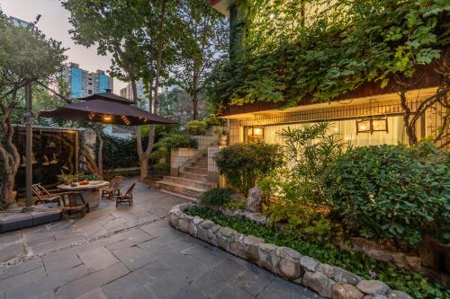 an outdoor patio with a table and an umbrella at PuYuan Laoyangfang Huayuan GuestHouse in Xi'an