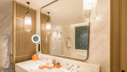 a bathroom with two sinks and a large mirror at MGM Shanghai West Bund in Shanghai