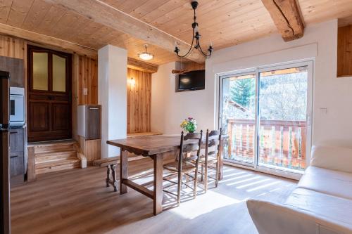 une cuisine et une salle à manger avec une table et des chaises en bois dans l'établissement Appartement Des Fontaines Albiez, à Albiez-le-Jeune