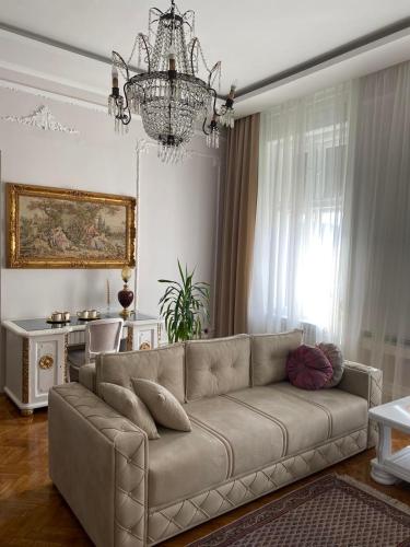 a living room with a couch and a chandelier at Apartments & Room - Korzo in Sombor