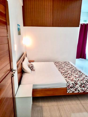 a small bedroom with a bed in a room at Coastal lodge in Port Mathurin
