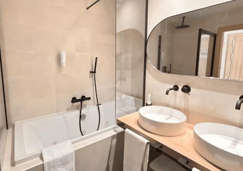 a bathroom with two sinks and a mirror at Hotel Real in Lleida