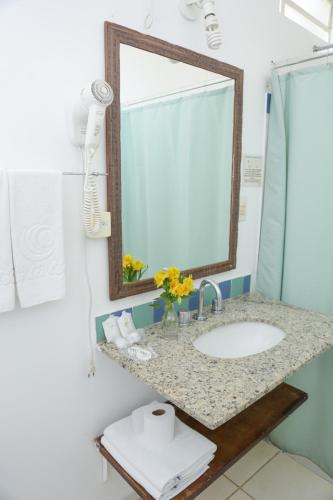 a bathroom with a sink and a mirror at Pousada Villa dei Colori in Araraquara