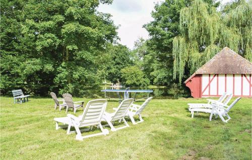 a group of chairs and a table in the grass at Maison Du Lac in Beaumontel