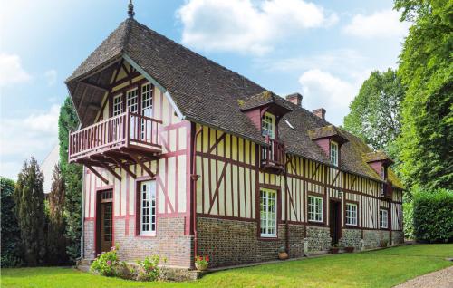 une vieille maison avec un bâtiment rose et jaune dans l'établissement Maison Du Lac, à Beaumontel