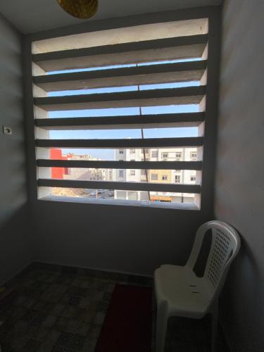 a window with a white chair in a room with a building at Cozy, secure and perfect for family stays in Agadir