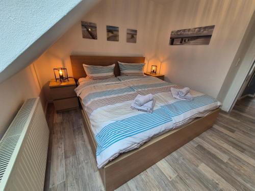 a bedroom with a large bed with towels on it at Chillmöwe in Norddeich