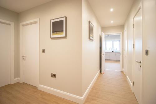a hallway of a home with white walls and wood floors at The Maltings in Portlaoise