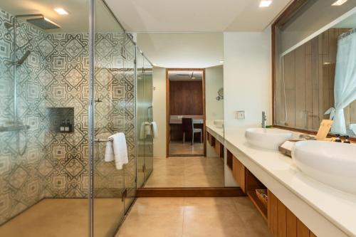 a bathroom with two sinks and a glass shower at Zenmaya Oceanfront Phuket, Trademark Collection by Wyndham in Patong Beach