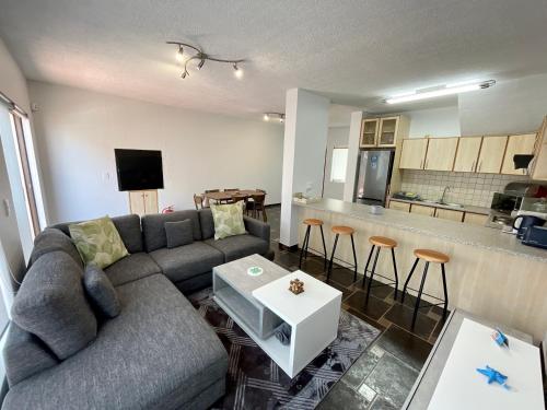 a living room with a couch and a kitchen at Salty Sunset Self Catering in Langstrand