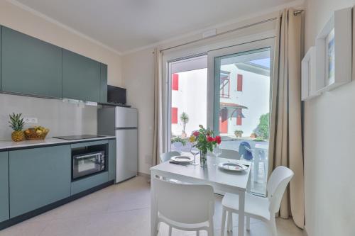 a kitchen with a table and chairs and a window at Camping Village Le Calanchiole in Capoliveri