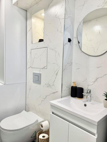 a white bathroom with a toilet and a sink at Comfort & Classy 1Bed Аpartment for 4 Guests on High Street in Stara Zagora