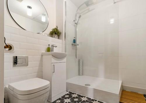 Un baño con inodoro, lavabo y espejo. en Central 1BD with Free Underground Parking!, en Cheltenham