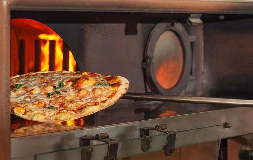 a pizza is being cooked in an oven at 3 Bedroom Gorgeous Home In Albarella Ro in Isola Albarella