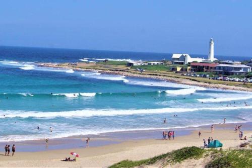 a group of people on a beach near the ocean at Jeffreys Bay - Life on the Canals in Jeffreys Bay