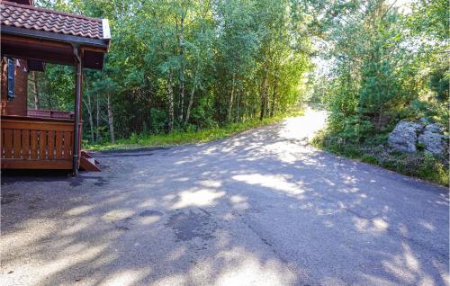 a dirt road next to a house and trees at Nice Home In Lindesnes With Sauna in Svenevik