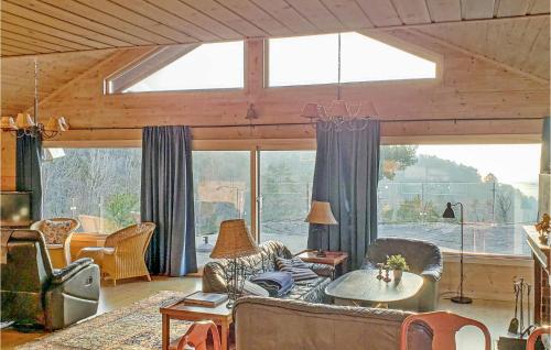 a living room with couches and a large window at Nice Home In Lindesnes With Sauna in Svenevik