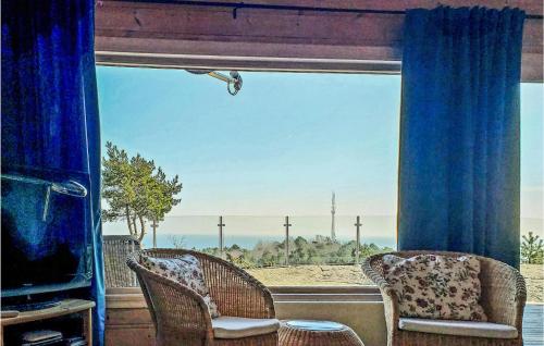 a room with two chairs and a large window at Nice Home In Lindesnes With Sauna in Svenevik