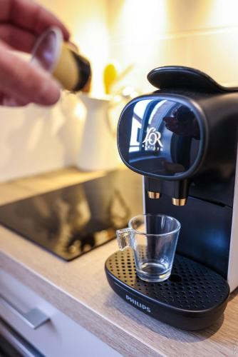 - une cafetière avec un verre sur un comptoir dans l'établissement N5 Le Studio de Montaudry - Calme - Parking, à Albi