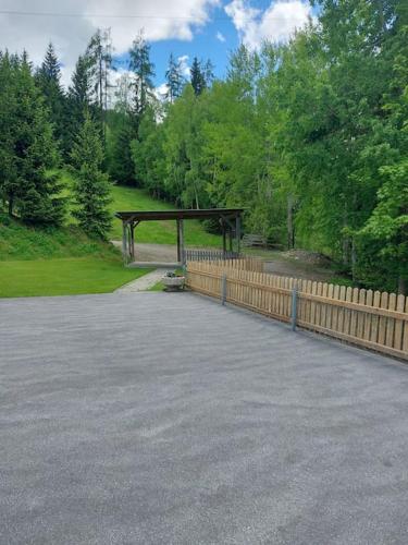 a parking lot with a wooden fence and trees at Ferienwohnung Ortner am Kreischberg in Sankt Lorenzen ob Murau