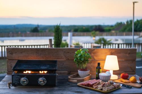 - une table avec un grill, des aliments et une lampe dans l'établissement Camping Le Sequoia, à Payrac