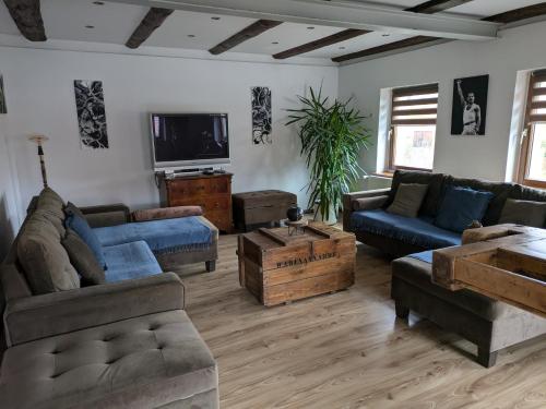 a living room with couches and a tv at Ferienhaus -Am alten Dorfplatz- in Dresden