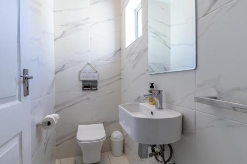 a white bathroom with a sink and a toilet at NeverEndingStory in Yzerfontein