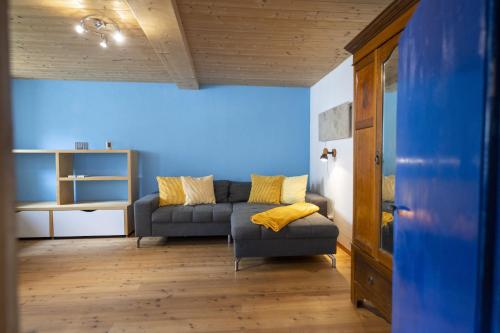 a living room with a couch and a blue wall at Chasa San Geer Sains in Scuol