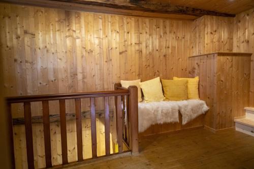 a room with a bed in a wooden wall at Chasa San Geer Sains in Scuol