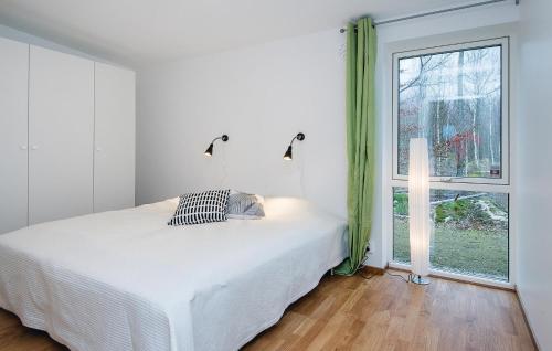 a white bedroom with a bed and a window at Three-Bedroom Holiday Home Holmsjö With A Fireplace 06 in Holmsjö