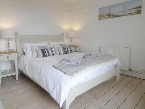 a bedroom with a white bed with towels on it at Ley Park in Bideford