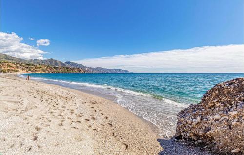 a beach with rocks and the ocean on a sunny day at Pet Friendly Home In Malaga in Málaga