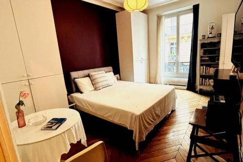 une petite chambre avec un lit et une table dans l'établissement Central Paris Bohémien and Arty Apt, à Paris