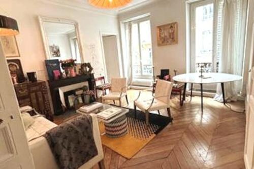 un salon avec un canapé et une table dans l'établissement Central Paris Bohémien and Arty Apt, à Paris